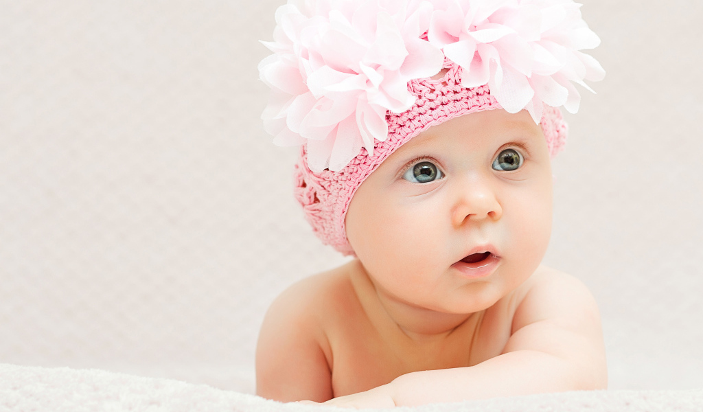 Маленькая девочка в вязаной шапке с цветами