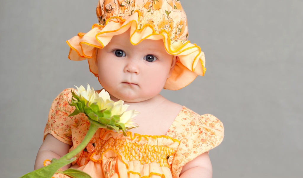 Маленькая девочка в красивом наряде с цветком