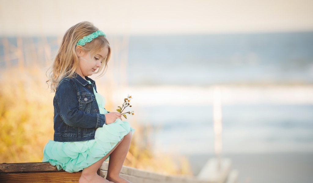 Маленькая девочка сидит на мосту