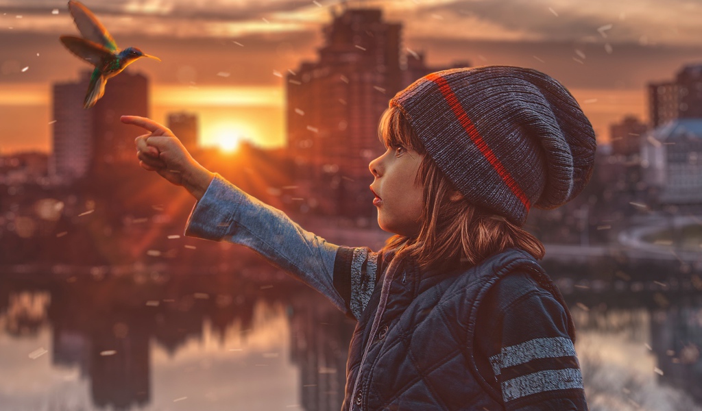 Маленькая девочка с птицей колибри на фоне города