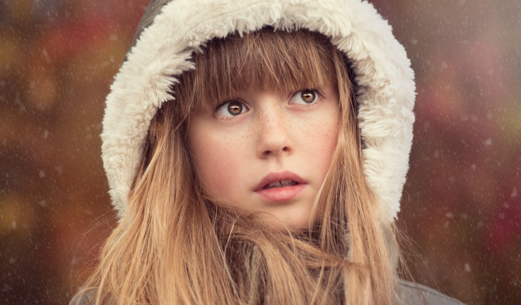 Маленькая девочка с веснушками на лице в капюшоне 