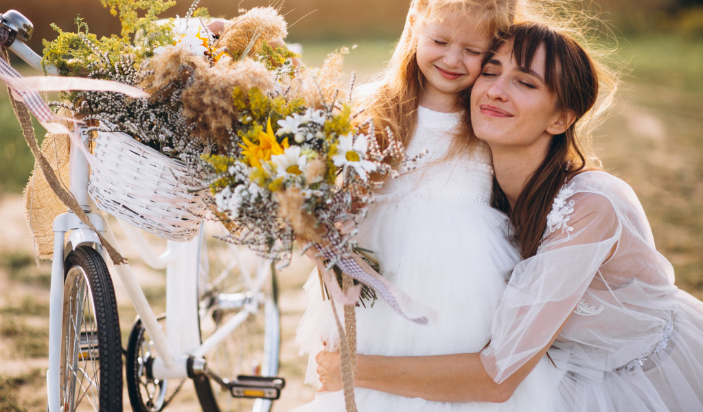 Маленькая девочка с мамой у велосипеда