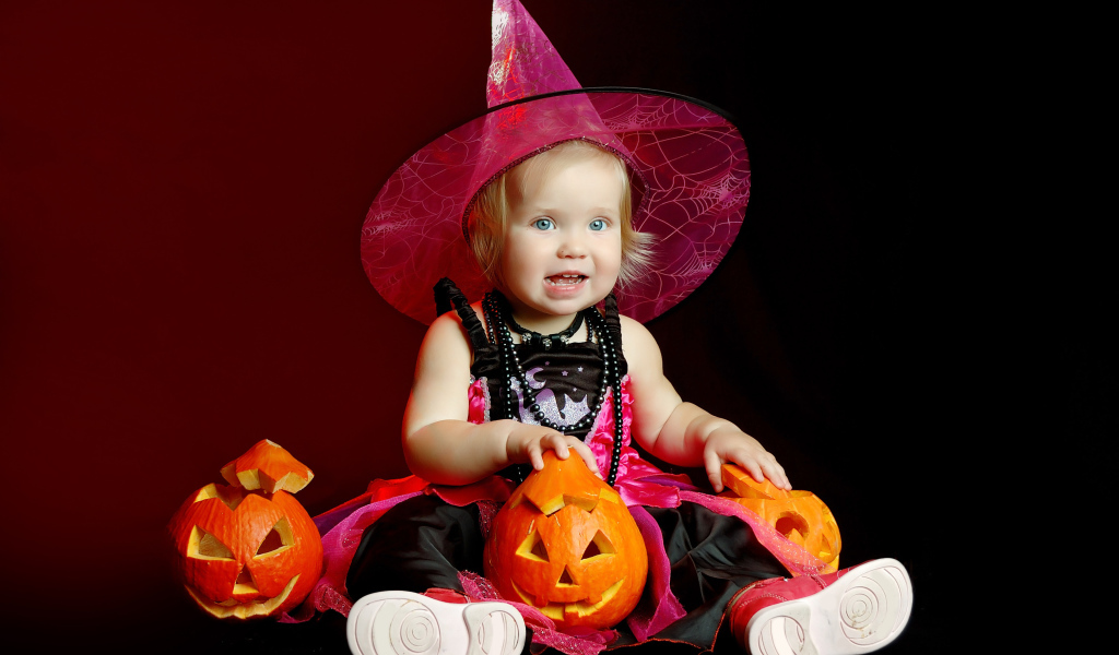 Маленькая девочка с тыквой в костюме на праздник Хэллоуин 