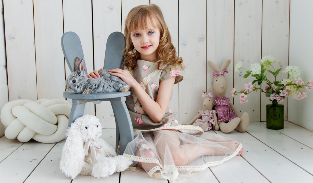 Маленькая девочка с игрушками в комнате сидит на полу