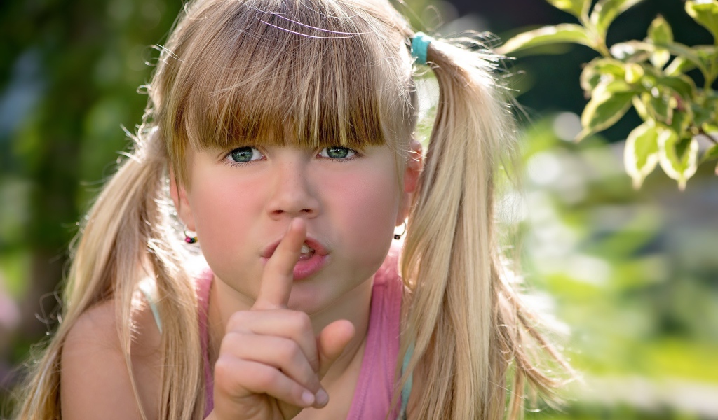 Маленькая зеленоглазая девочка с пальцем у рта 