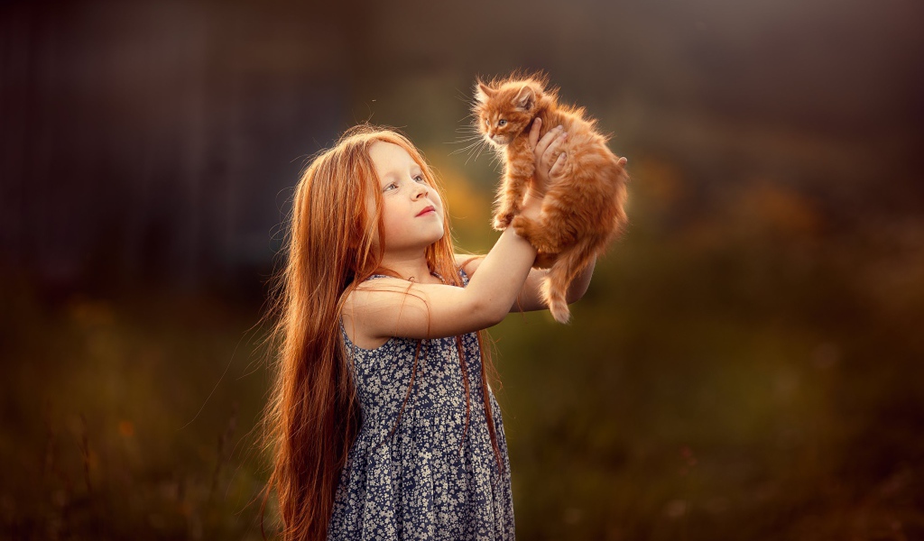 Маленькая рыжеволосая девочка с рыжим котенком в руках