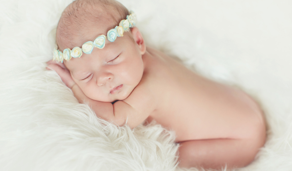 Маленький спящий ребенок на меховом покрывале