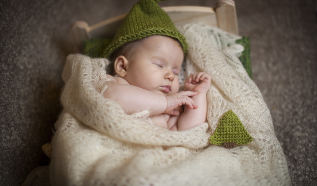 Спящий младенец лежит на пуховом платке