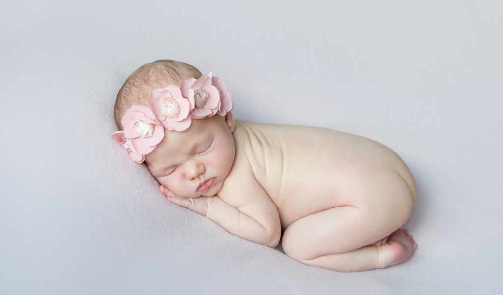 Спящая девочка с розовым венком на голове
