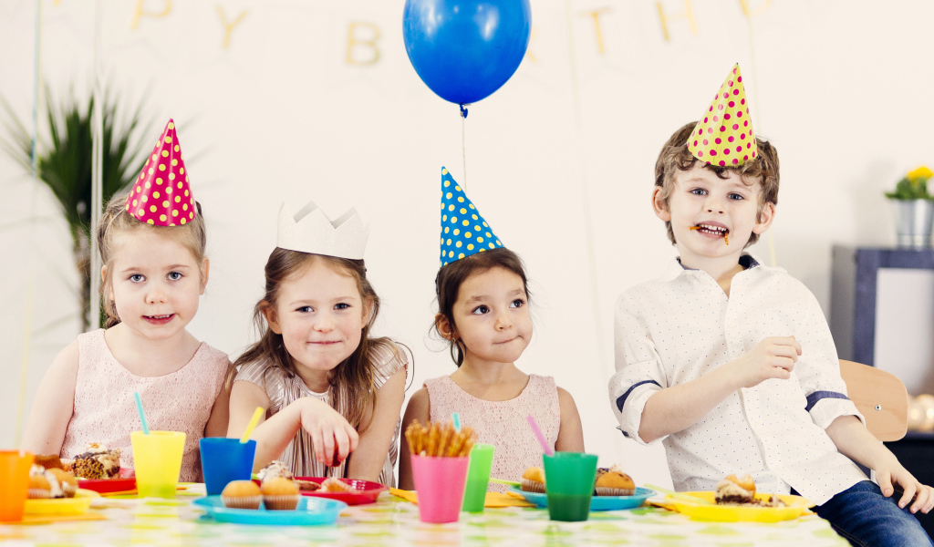 Маленькие дети отмечают детский праздник за столом