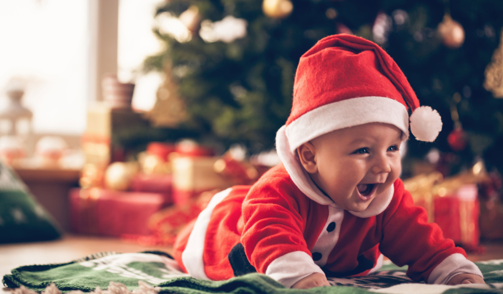 Улыбающийся малыш в новогоднем костюме у елки