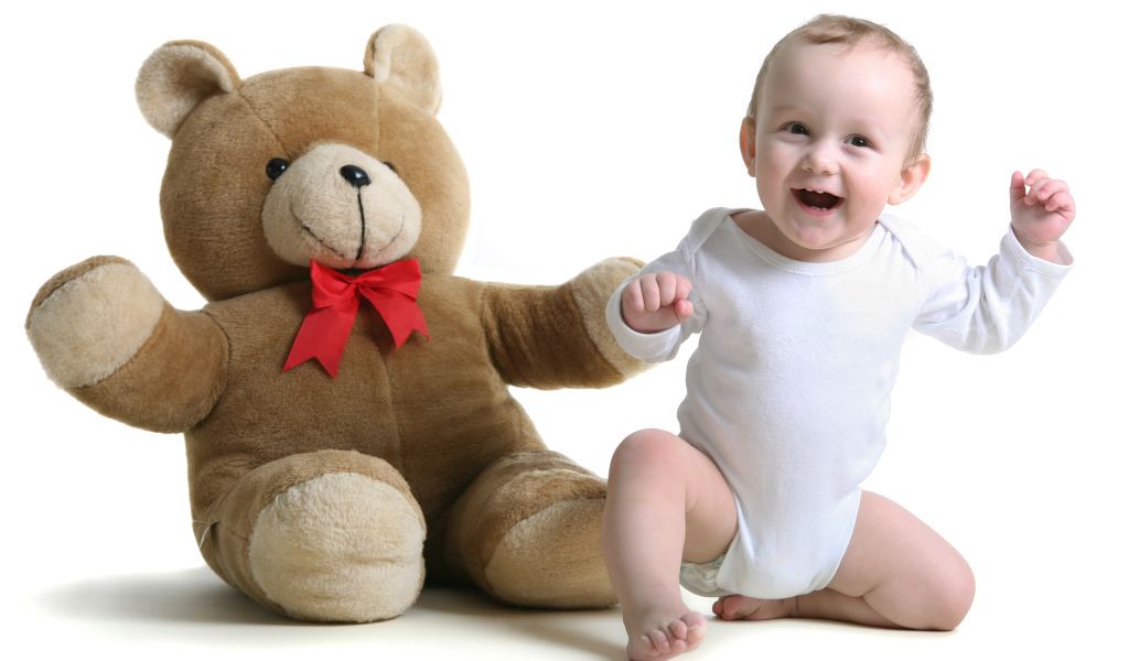 Улыбающийся малыш в большим игрушечным медведем