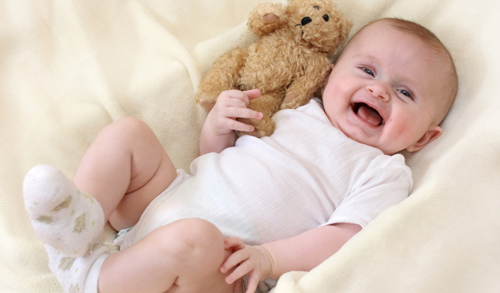 Улыбающийся малыш с медвежонком Тедди 