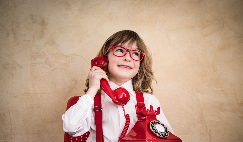 Улыбающийся мальчик с красным телефоном