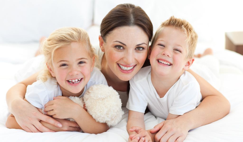 Улыбающаяся мама с двумя детьми