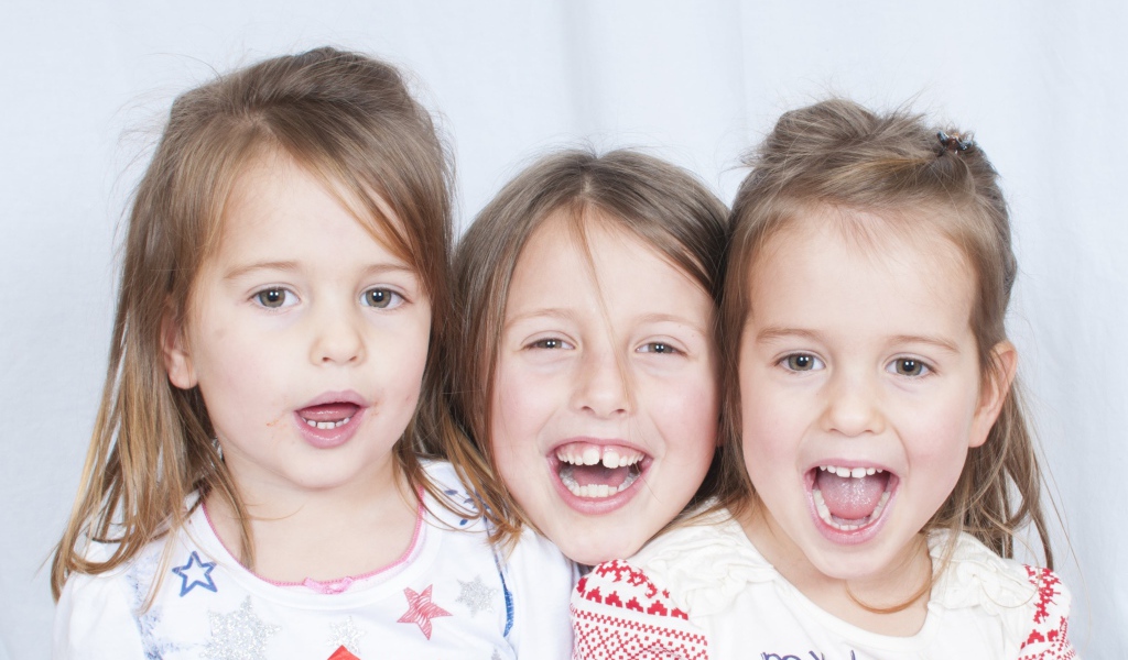 Три маленькие улыбающиеся девочки сестры 