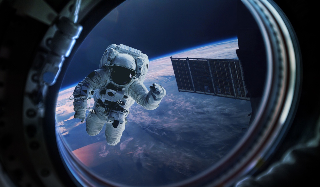 Астронавт в иллюминаторе в космосе