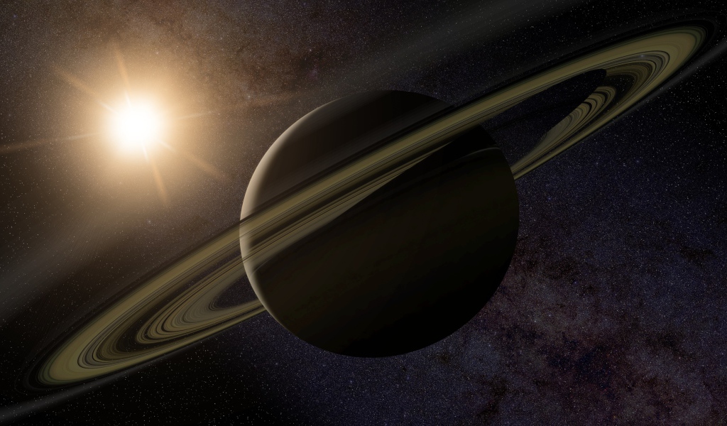 Планета Сатурн с кольцами на фоне солнца