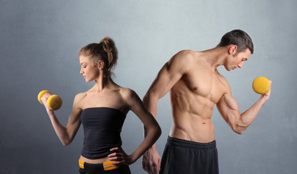 Девушка и парень занимаются спортом с гантелями