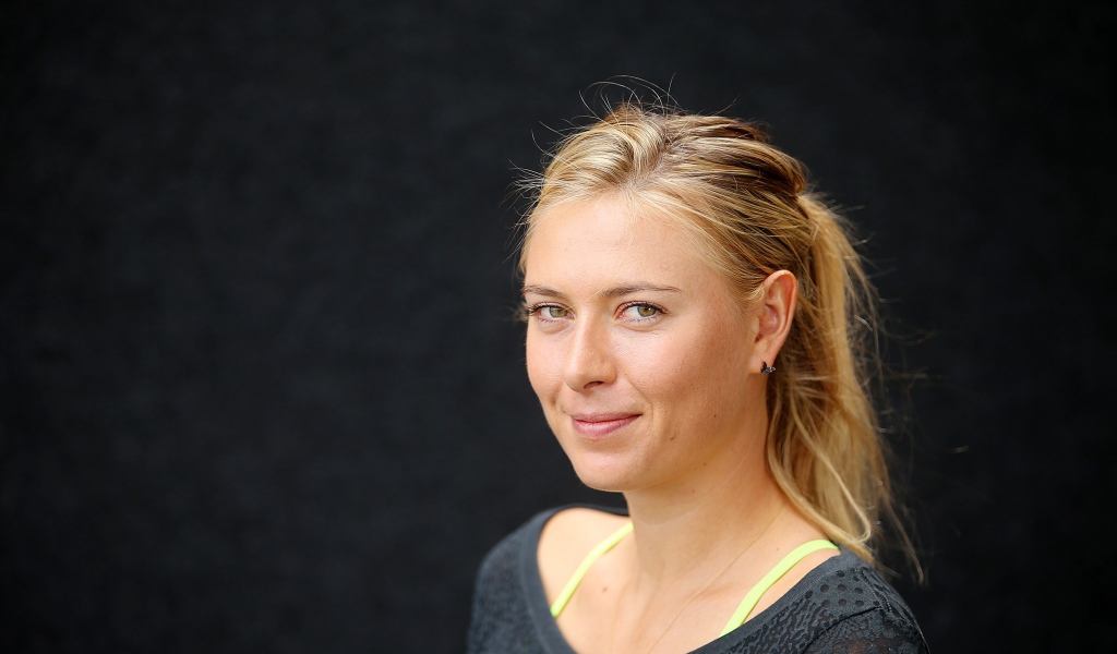 Улыбающаяся блондинка, теннисистка Мария Шарапова на сером фоне