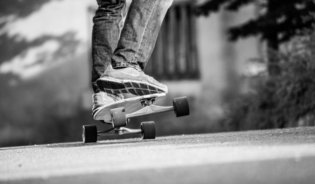 Парень катается на скейтборде по асфальту