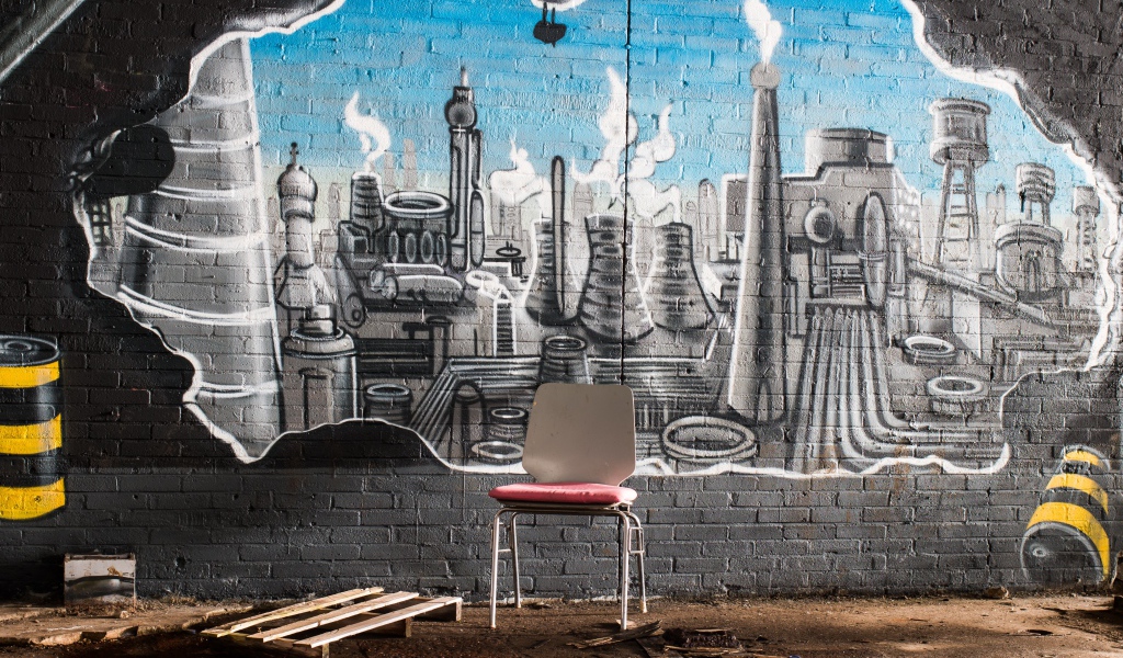 Стул стоит у кирпичной стены с граффити