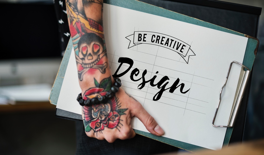 Мужчина с татуировкой на руке держит папку