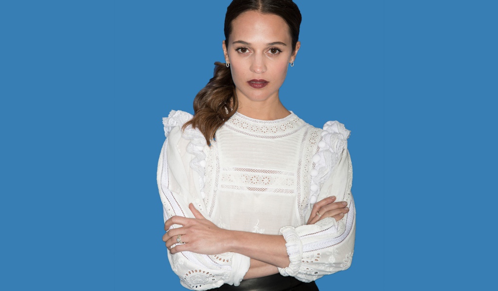 Актриса Алисия Викандер в белой блузке на синем фоне