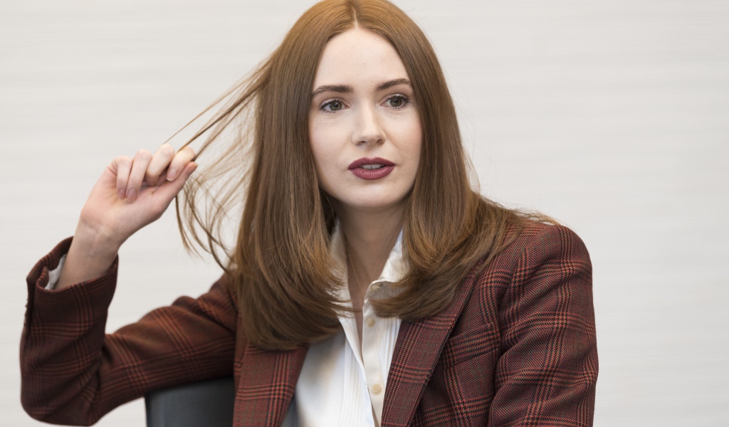 Актриса Карен Гиллан в пиджаке держит волосы
