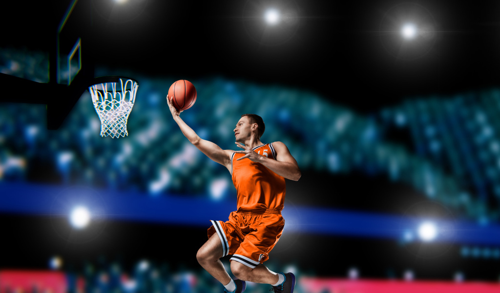 Парень баскетболист бросает мяч в кольцо