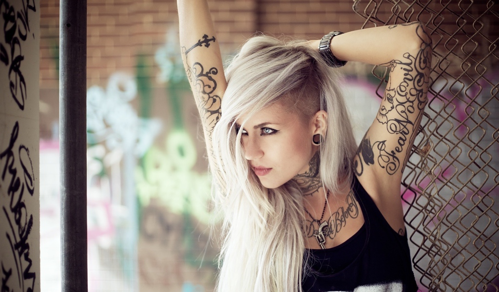 Красивая блондинка с татуировками на теле