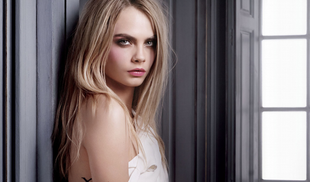 Красивая девушка, актриса Кара Делевинь у стены