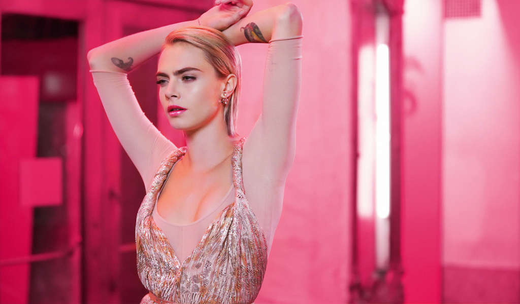 Красивая девушка актриса Кара Делевинь на розовом фоне