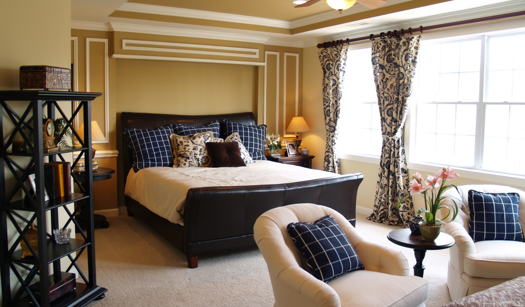 Спальня с большой кожаной кроватью и креслами 