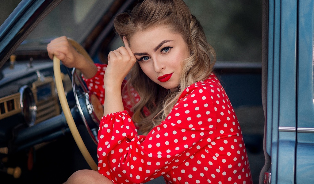 Голубоглазая ретро девушка за рулем автомобиля 