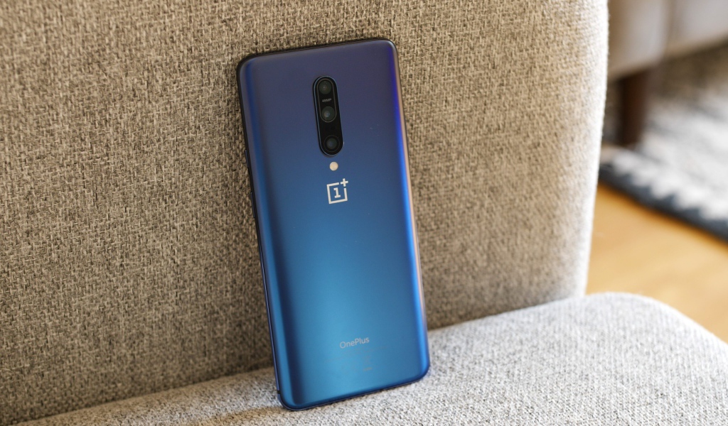 Синий смартфон ONEPLUS 7 на диване