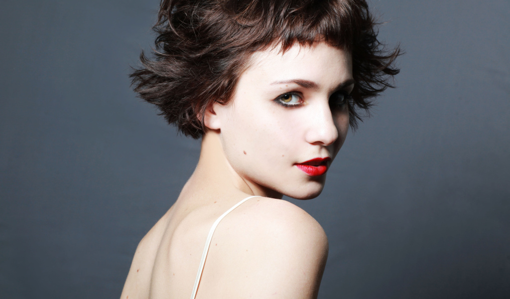 Яркая девушка с короткой стрижкой, актриса Таппенс Мидлтон на сером фоне