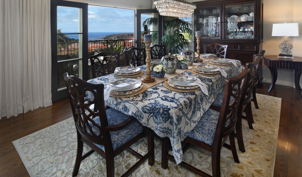 Столовая комната с большим дубовым столом  и красивой посудой