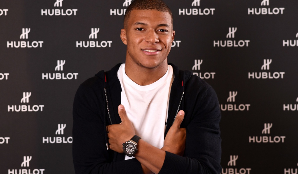 Футболист Килиан Мбаппе в костюме с часами на руке