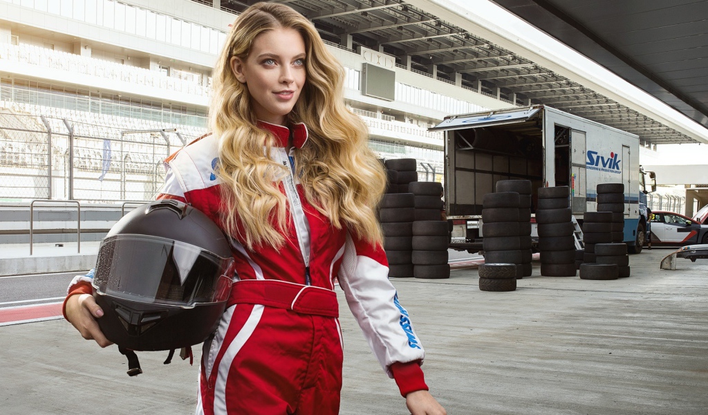 Девушка гонщица с шлемом в руках