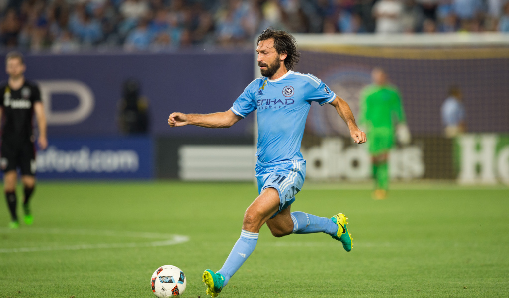 Итальянский футболист Андреа Пирло отбивает мяч на футбольном поле