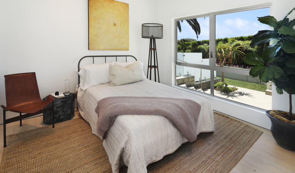 Большая кровать у окна в спальной комнате