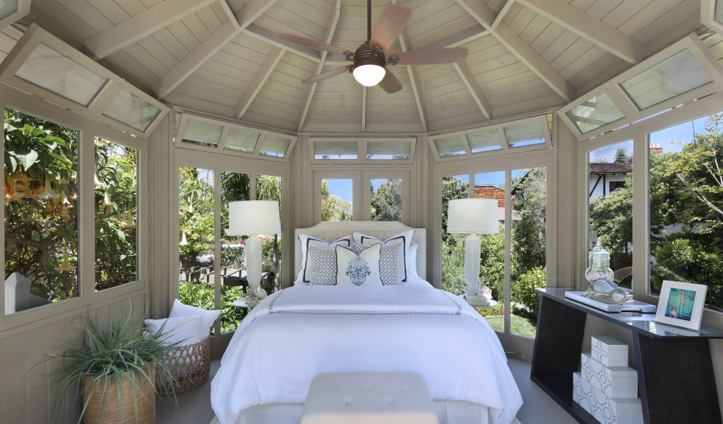 Большая спальная комната с окнами и белой кроватью 