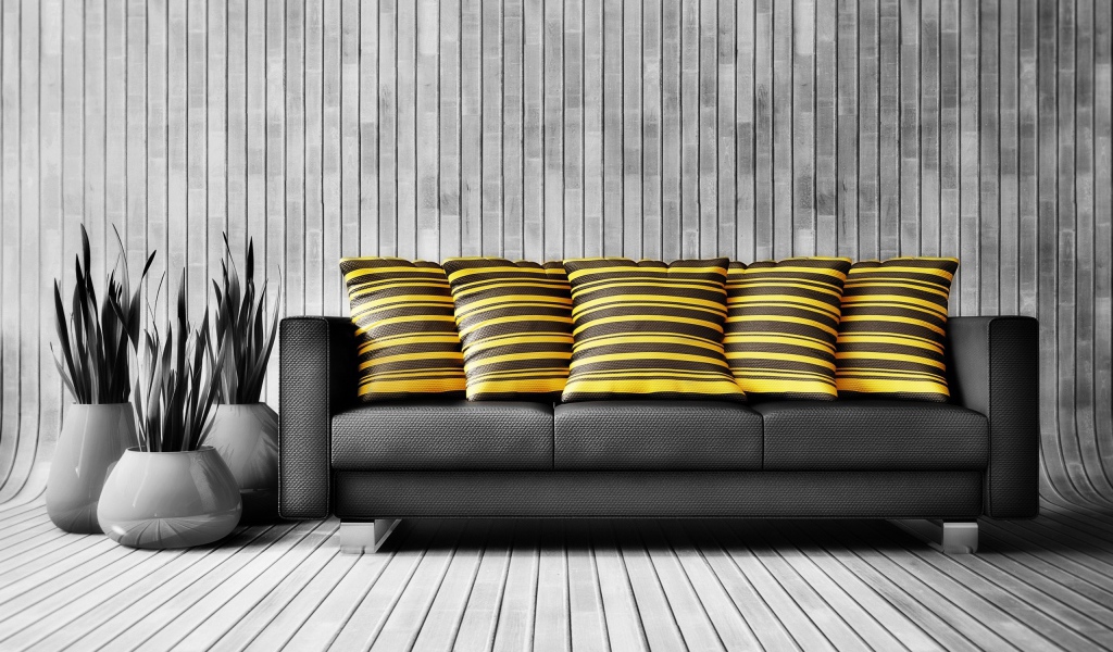 Большой черный кожаный диван с подушками у стены