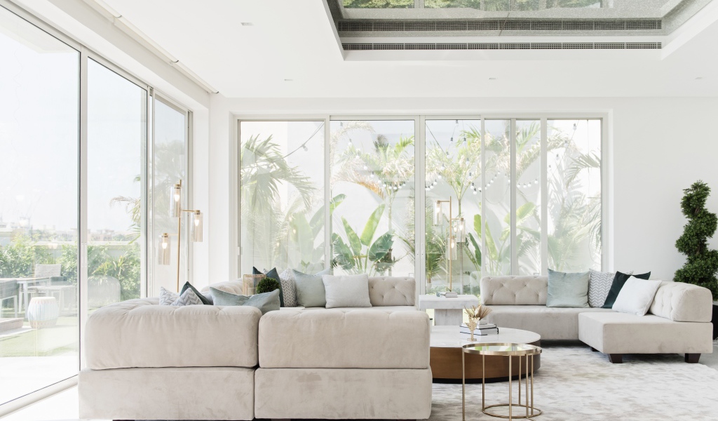 Большая гостиная комната с диваном и большими окнами