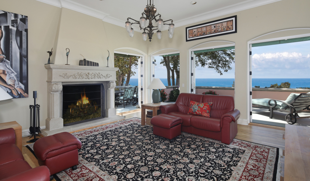 Гостиная с кожаным диваном, большими окнами и камином 