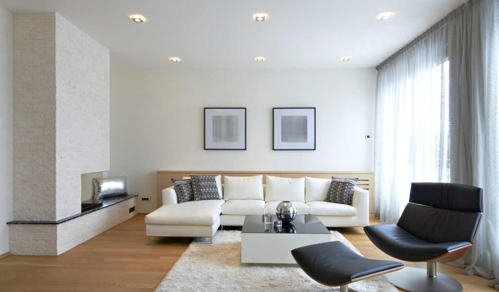 Гостиная комната с белым кожаным диваном и черным креслом у окна