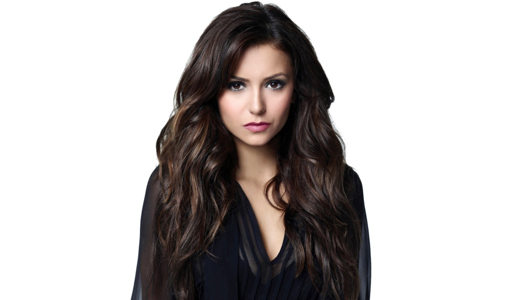 Длинноволосая девушка актриса Нина Добрев на белом фоне