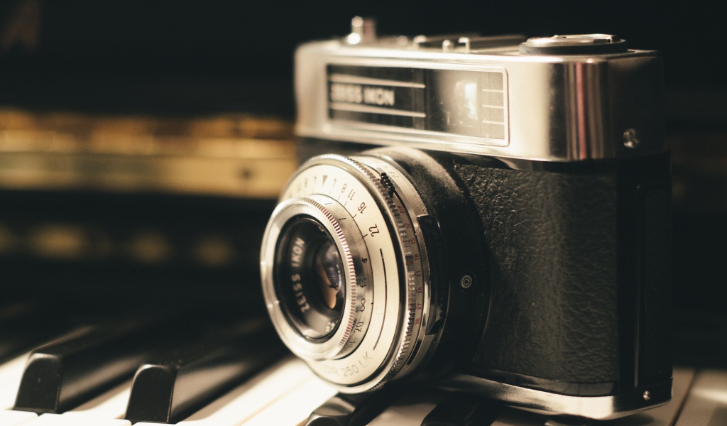 Старый фотоаппарат Zeiss Ikon стоит на клавишах пианино