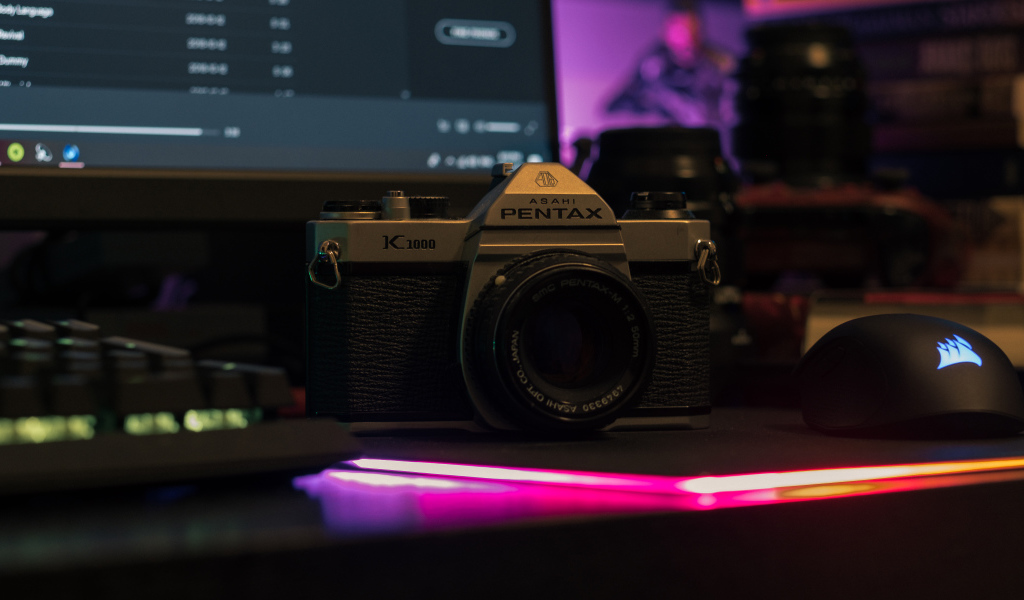 Фотоаппарат Pentax на столе с компьютером